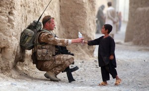 soldier giving water to young boy