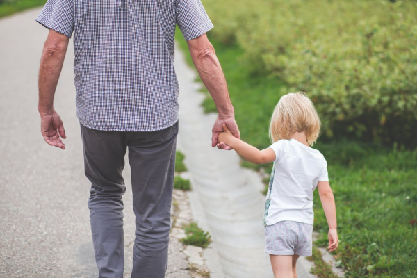 Man and young daughter holding hands