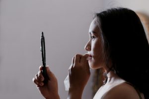 woman looking at herself in hand held mirror