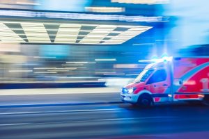 ambulance driving down road with lights