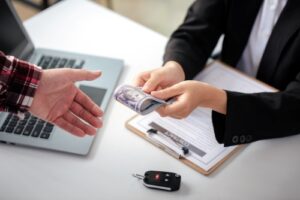 The salesperson delivers the money to the owner of the car