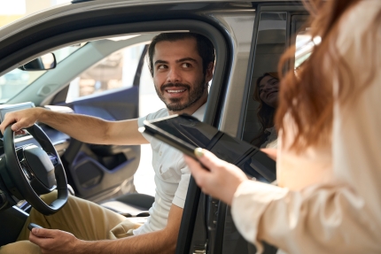 Joyous buyer communicating with automotive sales consultant